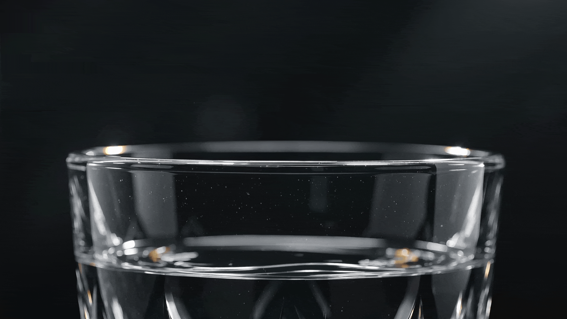 Prompt: "Close-up of a crystal glass shattering in ultra-slow motion, water splashing outwards, dark background, dramatic rim lighting, high-speed macro cinematography."