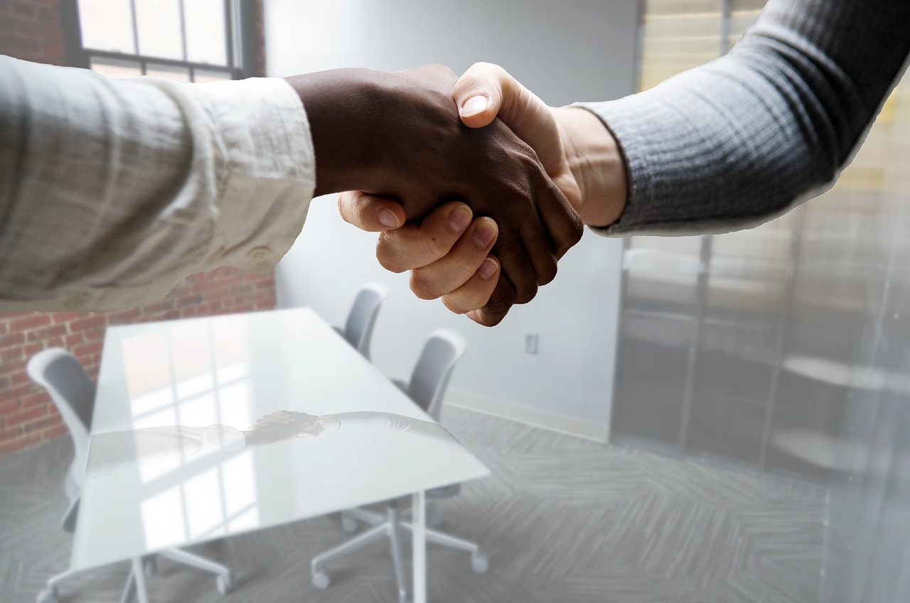 two hands holding together, after a successful hiring by improving hiring velocity