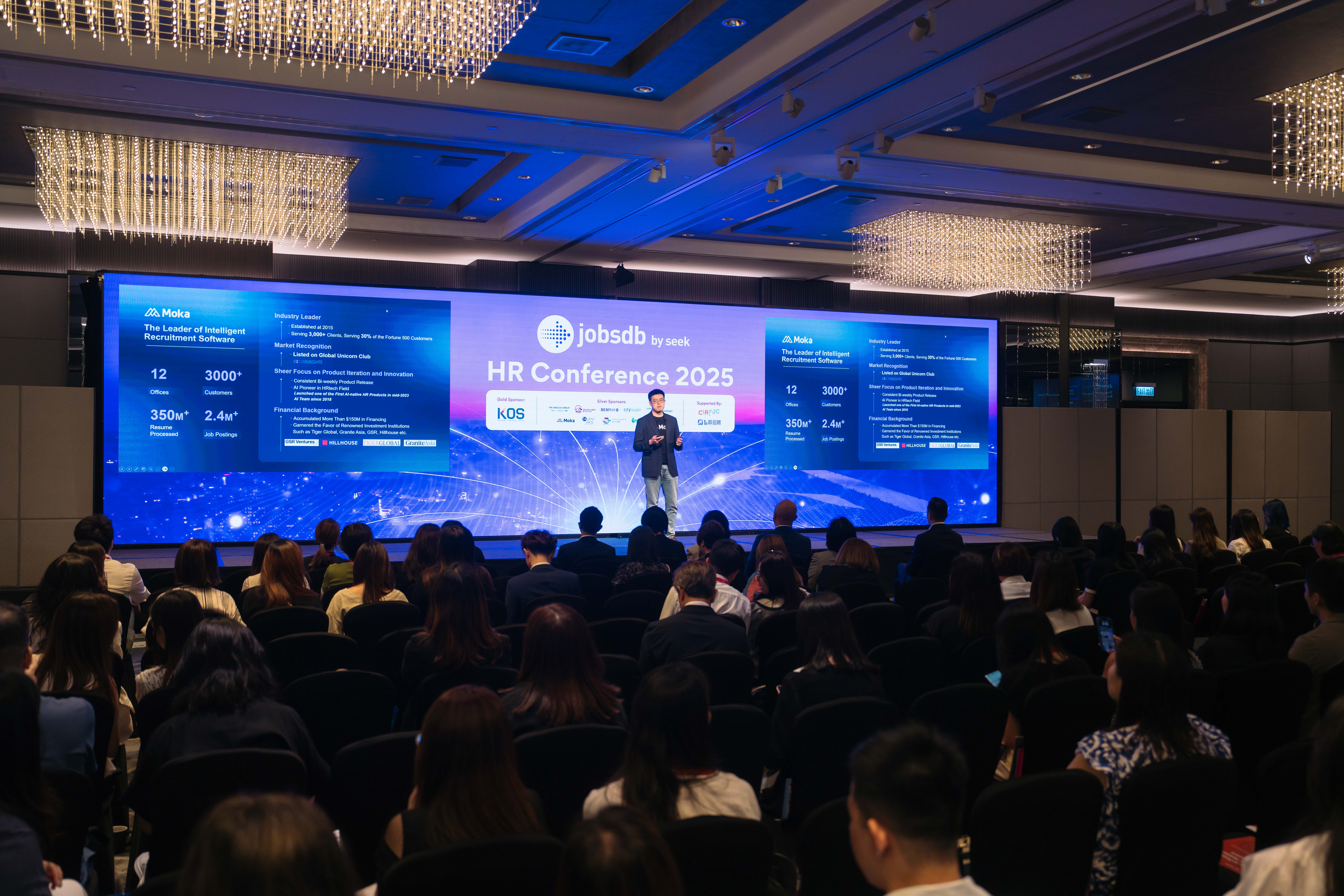Wide view of the JobsDB HR Conference 2025 main stage with the CEO Guoxing introducing Moka as an industry pioneer , and seated audience.