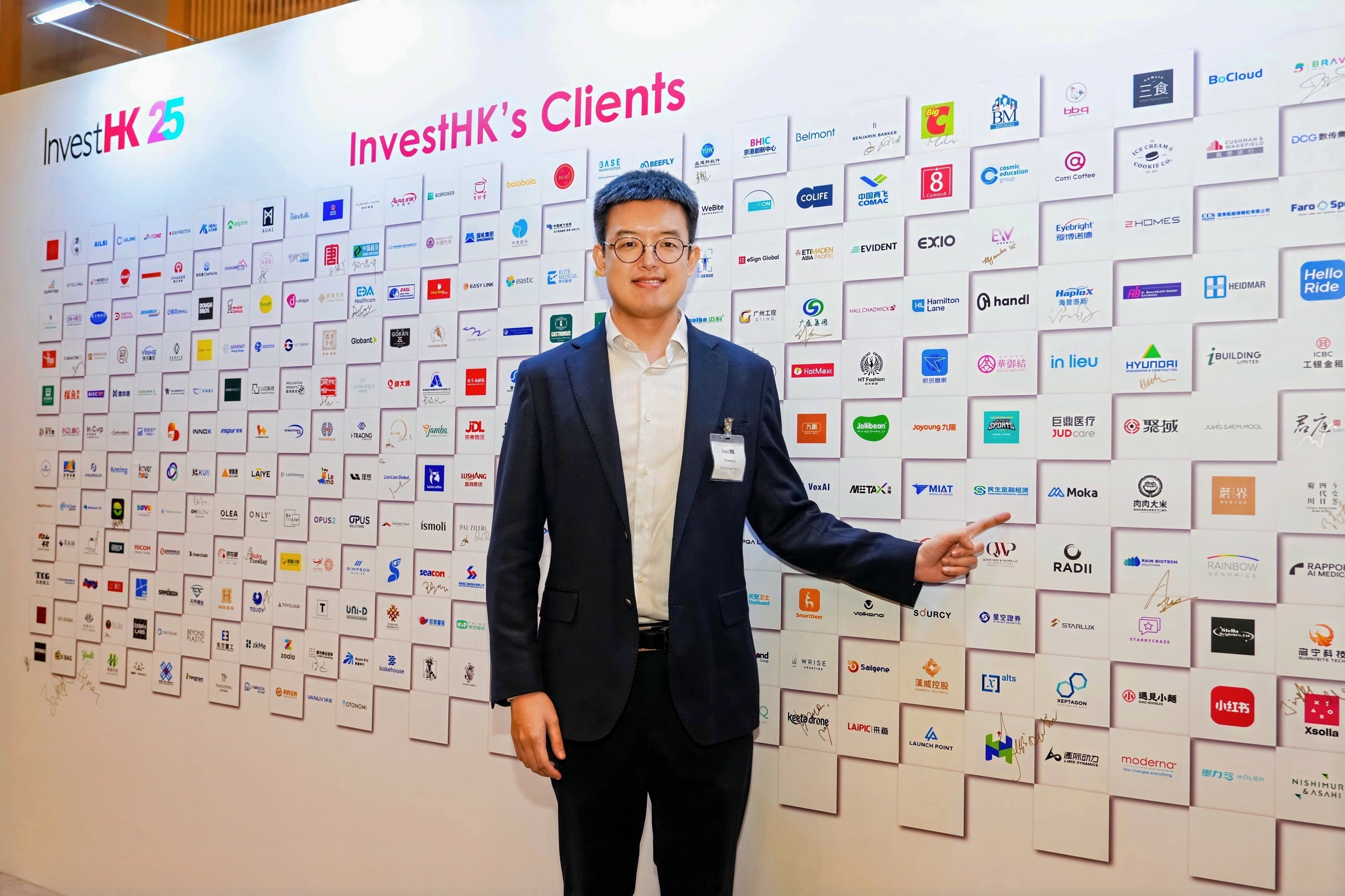 Guoxing points at the company’s logo displayed on the conference backdrop.