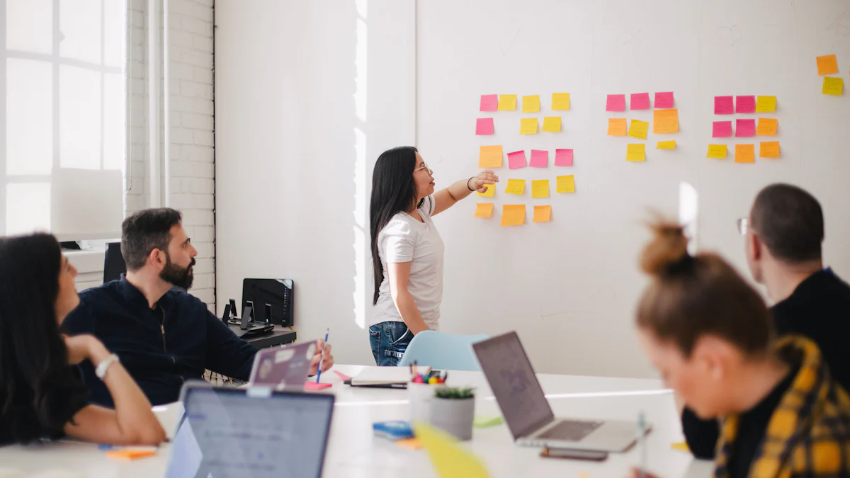How to Protect Your Boundaries Without Being Defensive 2 A woman stands near a whiteboard with colorful sticky notes, emphasizing the theme "Protect Your Boundaries," while four people sit at a table with laptops in the bright room.