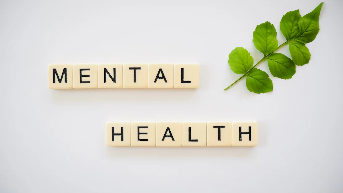 Scrabble tiles spelling "Mental Health" arranged on a white background next to a small green leaf evoke the essence of a Guide to Mental Wellness.