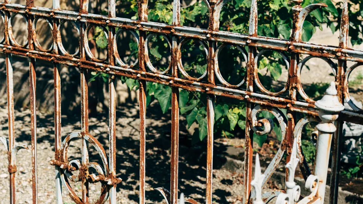 Rusted and corroded metal fence showing significant rust buildup