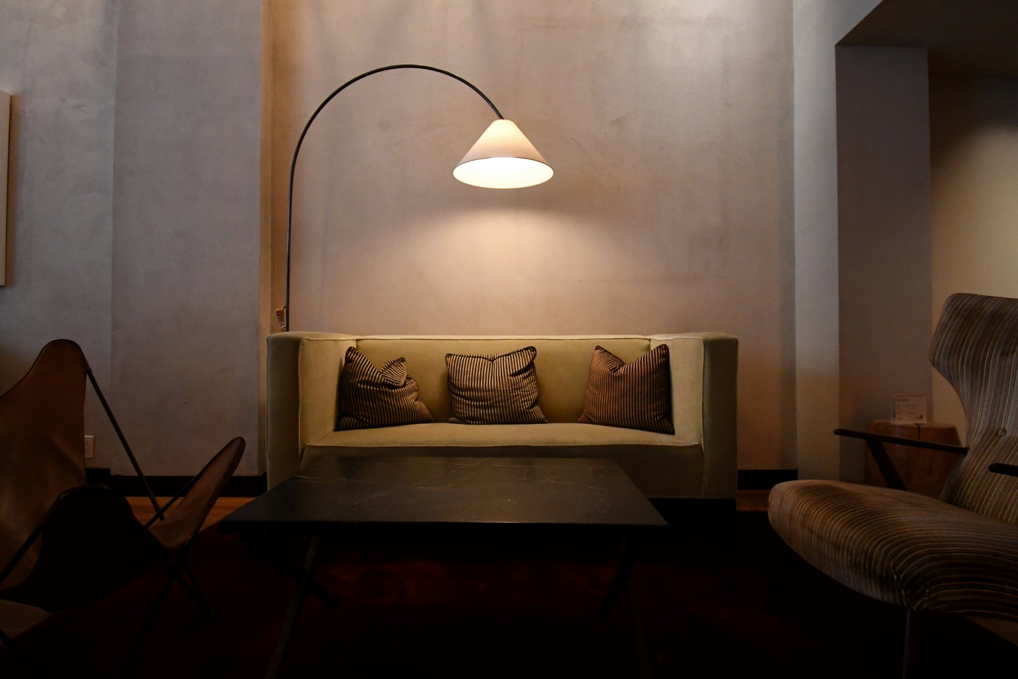 Modern living room with an arc floor lamp creating warm layered lighting
