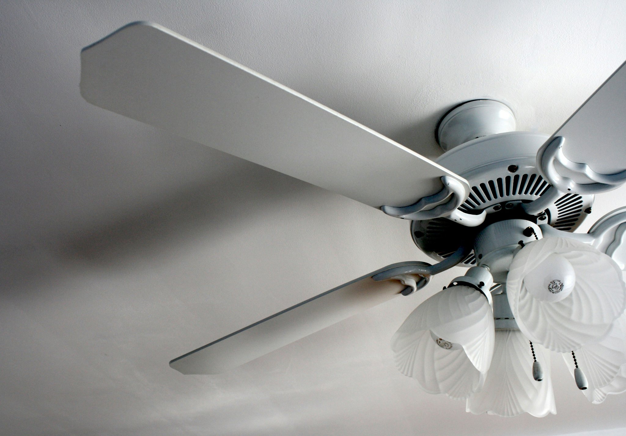 Modern white ceiling fan with integrated light installed in a bedroom